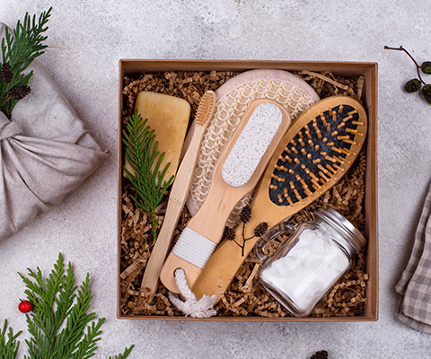 gift box containing wooden brush and natural soaps with green foliage and festive decorations for relaxation and self care 4 essentials