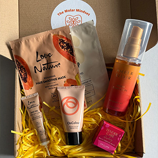 skincare gift box with hair and beauty products including a hair mask a foundation a spray and a lip treatment three beauty essentials